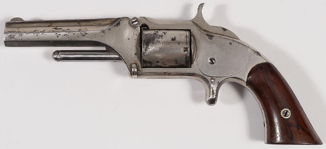 A SMITH & WESSON NO. 1 ½ FIRST ISSUE REVOLVER: A SMITH & WESSON NO. 1 ½ FIRST ISSUE REVOLVER. Serial number 21174, caliber .32 rimfire, 5-shot, 3.5-inch barrel, patent dates on top of barrel, rosewood grips, nickel finish (original), work