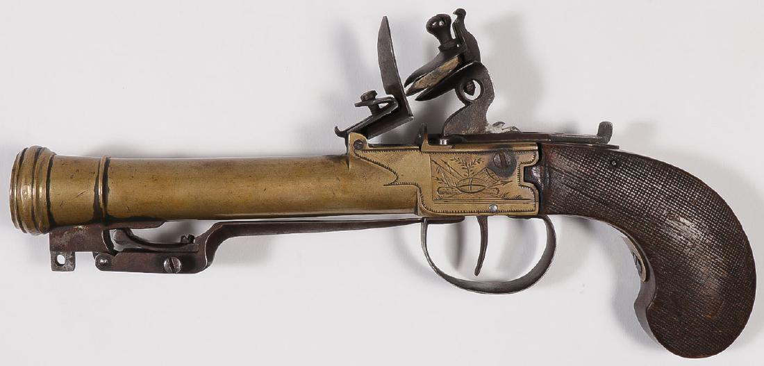 BOXLOCK FLINTLOCK BLUNDERBUSS PISTOL: BOXLOCK FLINTLOCK BLUNDERBUSS PISTOL WITH FOLDING BAYONET. The likely French made pistol with 5.25-inch brass barrel with flared muzzle, the sides of lock engraved with military trophies, finely c