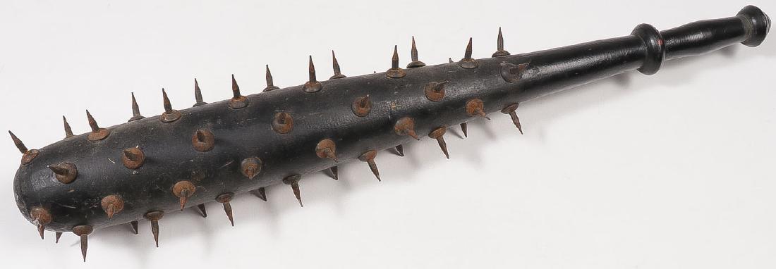 A BARBARIC SPIKED WOOD CLUB: A BARBARIC SPIKED WOOD CLUB. The large wood club with turned handle set with a multitude of iron spikes. Length 26.25 inches. SHIPPING NOTICE: Jackson's is your sole and only source for