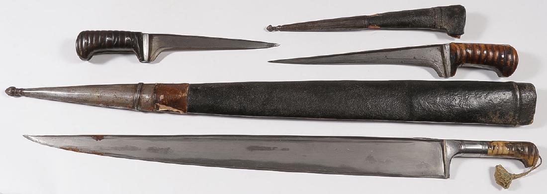 THREE KHYBER EDGED WEAPONS: THREE KHYBER EDGED WEAPONS. Comprising two daggers or knives, each with reinforced T-spine and with substantial horn ribbed handle grips, one with leather covered sheath and confirming metal tip, 