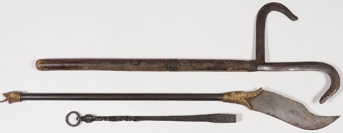 A PAIR OF INDO-TIBETAN HAND WEAPONS: A PAIR OF INDO-TIBETAN HAND WEAPONS. Each mounted on a sturdy staff, one with double hook blade, the other with shaped blade emanating from a cast brass open mouthed creature and with a wrought ir