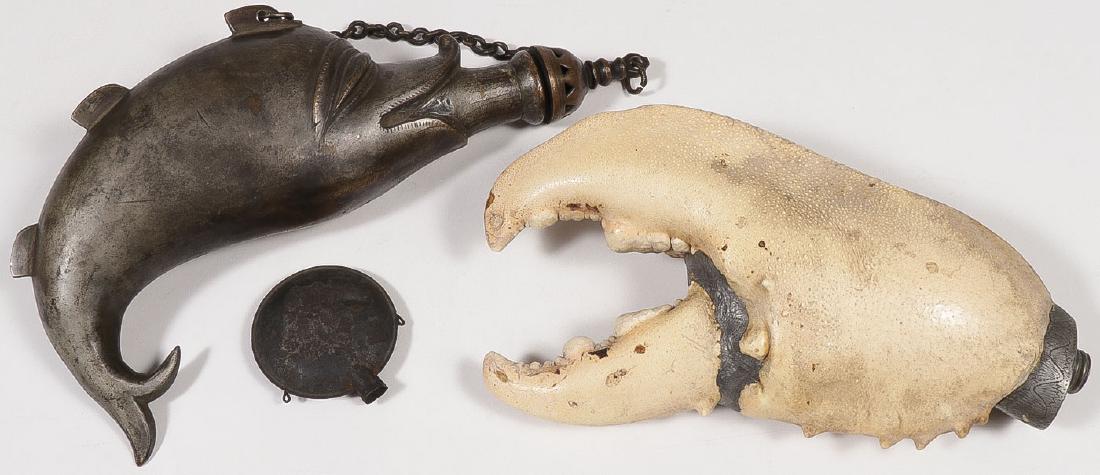 A PAIR OF FIGURAL POWDER FLASKS: A PAIR OF FIGURAL POWDER FLASKS. Comprising a brass fish form, the other constructed from a massive crab claw with engraved pewter spout missing cap, and a small tin GAR encampment souvenir canteen, g