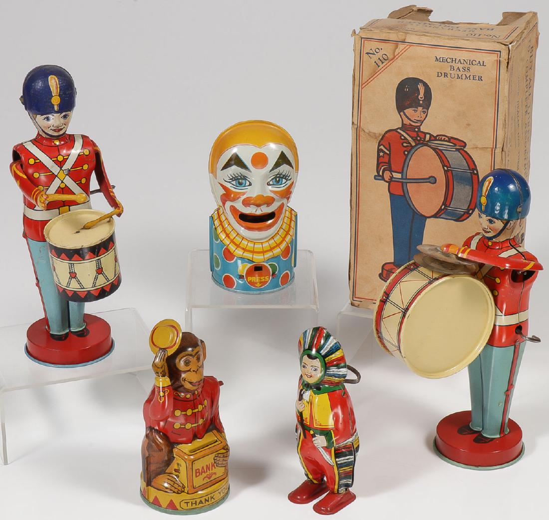 FIVE CHEIN TIN LITHO TOYS: FIVE CHEIN TIN LITHO TOYS. Comprising a wind-up bass drummer with fragmentary box, a snare drummer, a wind-up walking Indian boy, a monkey bank, and a clown bank. Greatest height 8.75 inches.