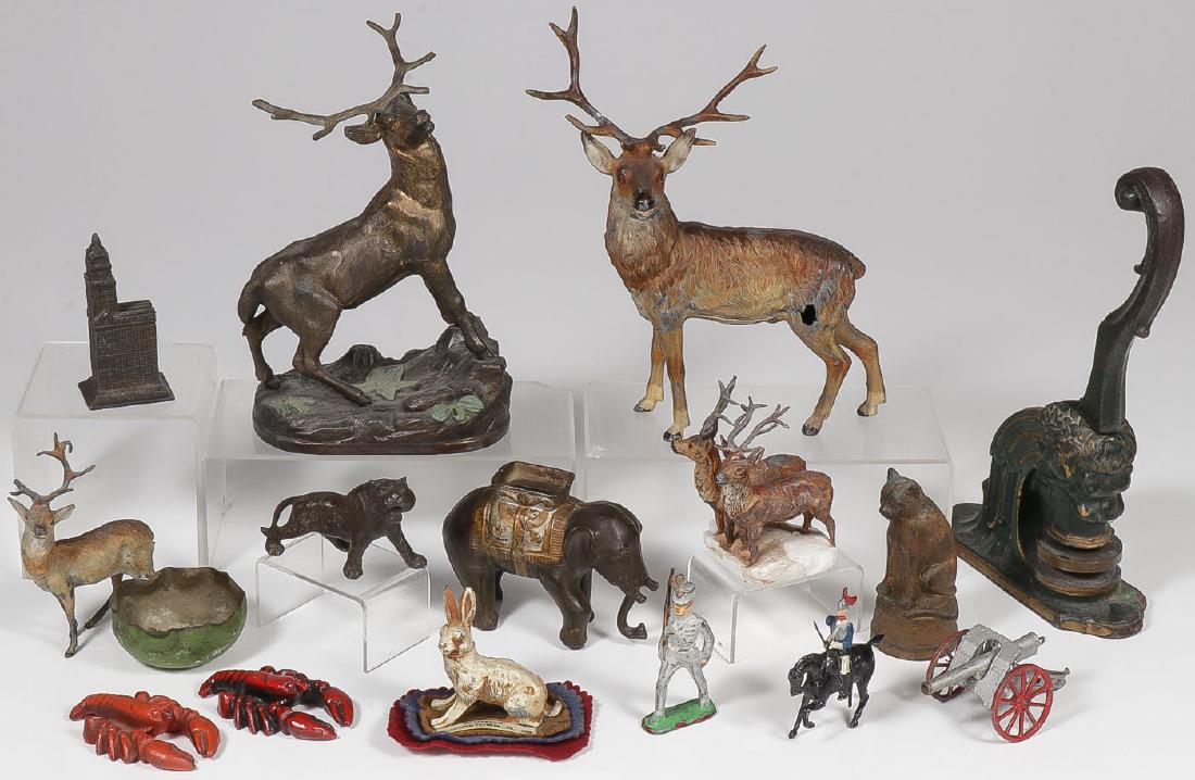 VINTAGE METAL DECORATIVE ARTS: VINTAGE METAL DECORATIVE ARTS. Comprising a cast iron elephant bank, a cast iron bank of cat seated on wash tub, a cast iron lion head embosser, a Hightstown, New Jersey cold painted metal rabbit souv