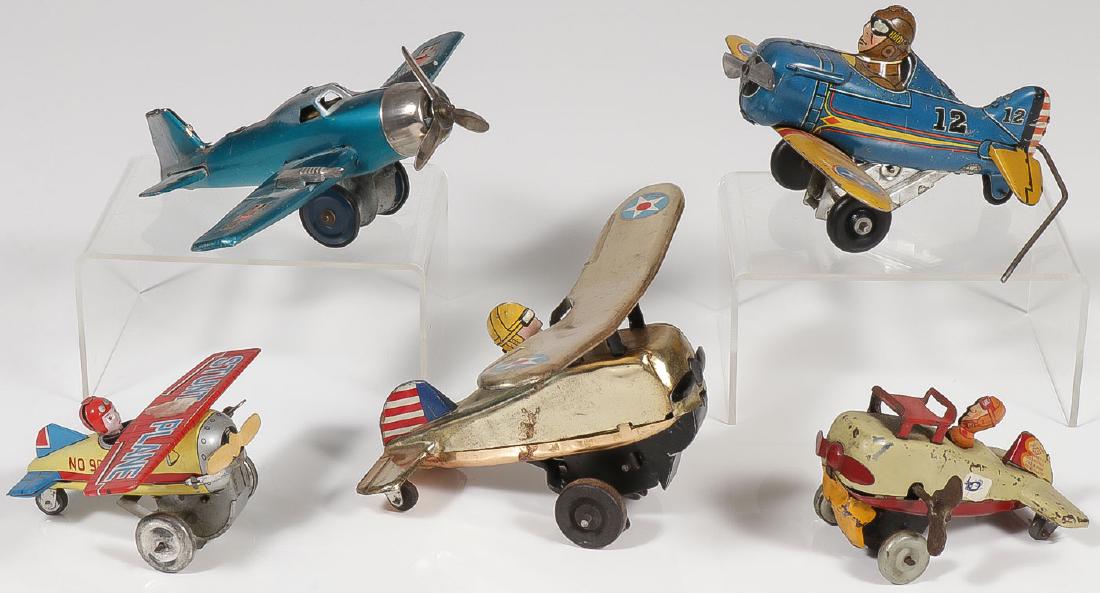FIVE VINTAGE TIN AIRPLANE TOYS: FIVE VINTAGE TIN AIRPLANE TOYS. Comprising a Marx front flip rollover airplane in good working order, a Marx blue and yellow side rollover (does not take wind), a Line Mar wind-up "Stunt Plane