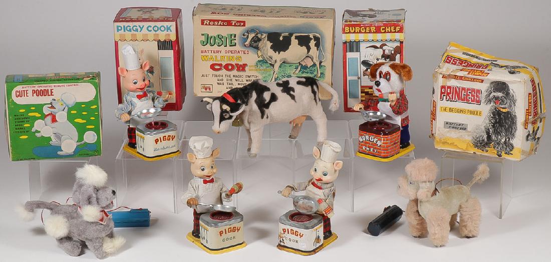 7 VINTAGE BATTERY POWERED TOYS: 7 VINTAGE BATTERY POWERED TOYS. Comprising a Cute Poodle in the original box, a Piggy Cook in the original box, a Rosko Josie walking cow with mooing voice with original box, an Amico Burger Chef dog
