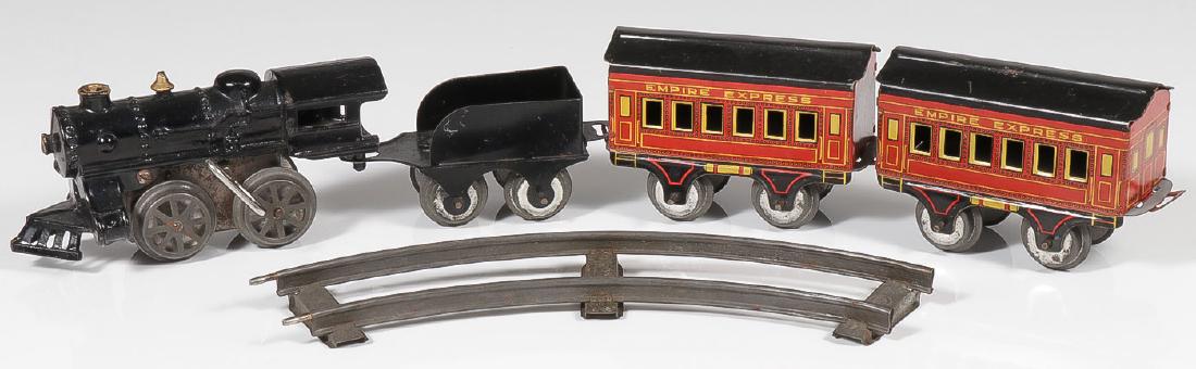 AN EMPIRE EXPRESS TRAIN SET: AN EMPIRE EXPRESS TRAIN SET. Comprising a clockwork wind-up cast iron engine with corresponding tin tender and two coaches. Provenance: From the lifetime collection of Thomas "Tom" W. A