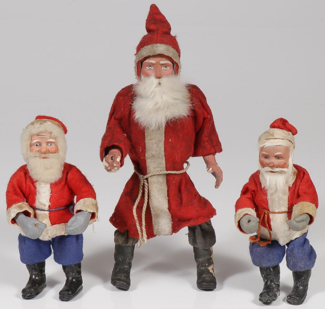 THREE GERMAN PAPIER-MACHE SANTAS: THREE GERMAN PAPIER-MACHE SANTAS. Comprising three good circa 1920 Santas or Father Christmases, each with finely modeled and painted papier-mache heads and with wire bodies, felt clothing, an