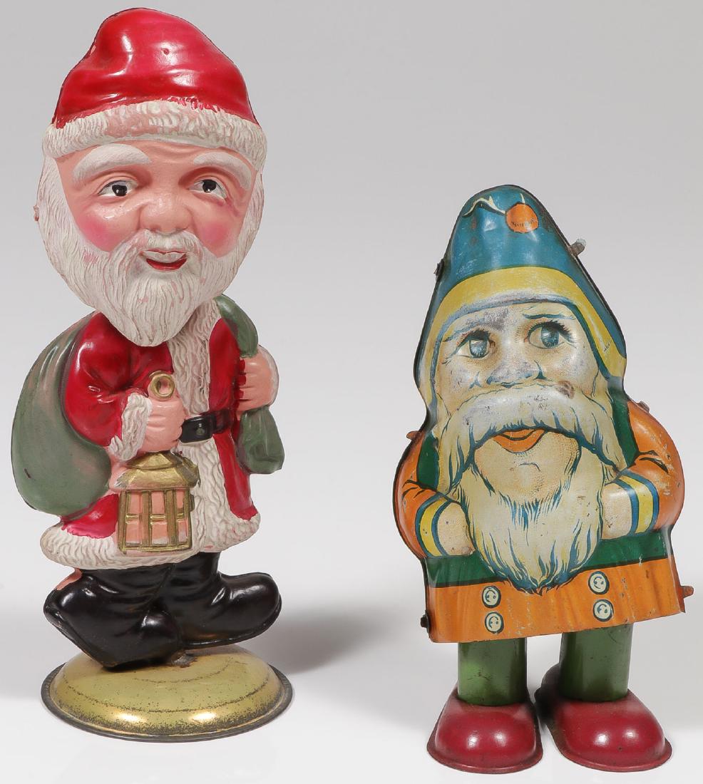 A PAIR OF VINTAGE SANTA TOYS: A PAIR OF VINTAGE SANTA TOYS. Comprising a good celluloid Japanese pendulum head Santa with colorful high relief molded body and pendulum swivel head mounted on original domed metal base and with pape