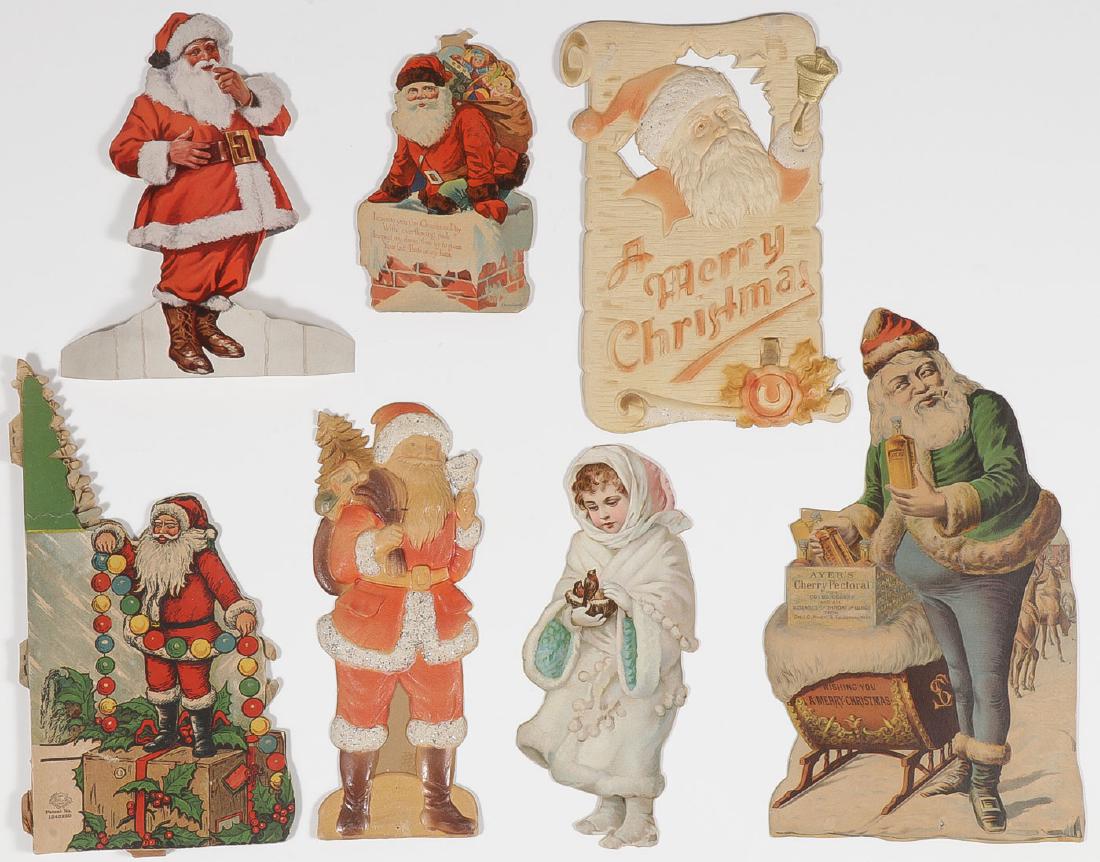 SEVEN EARLY SANTA DIE CUTS: SEVEN EARLY SANTA DIE CUTS. Including a great early "Ayer's Cherry Pectoral Medicine" die cut display (bottom right), height 12 inches, an embossed die cut Santa ringing bell emblazoned &#