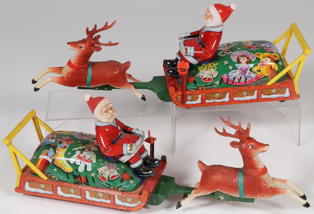 2 BATTERY-OPERATED VINTAGE SANTAS ON SLEIGH: 2 BATTERY-OPERATED VINTAGE SANTAS ON SLEIGH. Comprising two tin litho sleighs with tin litho Santa bodies mounted with vinyl heads and vinyl reindeer. Length 17.5 inches. Provenance: From the li