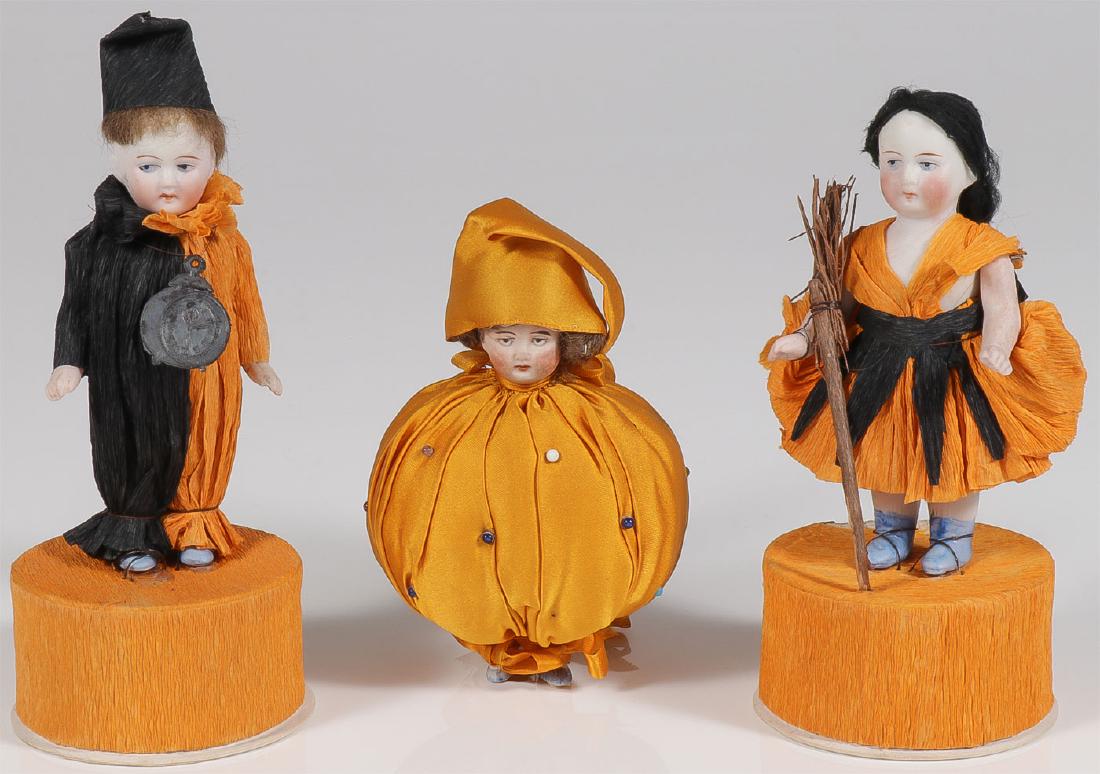 GREAT VINTAGE HALLOWEEN PORCELAIN, C 1900-1920: GREAT VINTAGE HALLOWEEN PORCELAIN, C. 1900-1920. Comprising two wonderful Halloween candy boxes mounted with German bisque dolls dressed in orange and black crepe costumes and resting atop a crepe