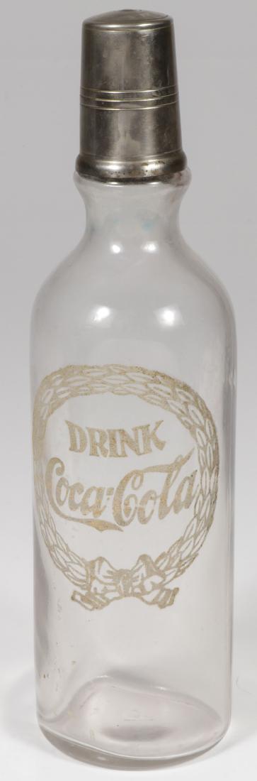 EARLY COCA-COLA SYRUP BOTTLE, C 1910: EARLY COCA-COLA SYRUP BOTTLE, C. 1910. With classic applied and fired wreath and logo design, with original nickeled cup cover. Height 12.25 inches. Provenance: From the lifetime collection of P