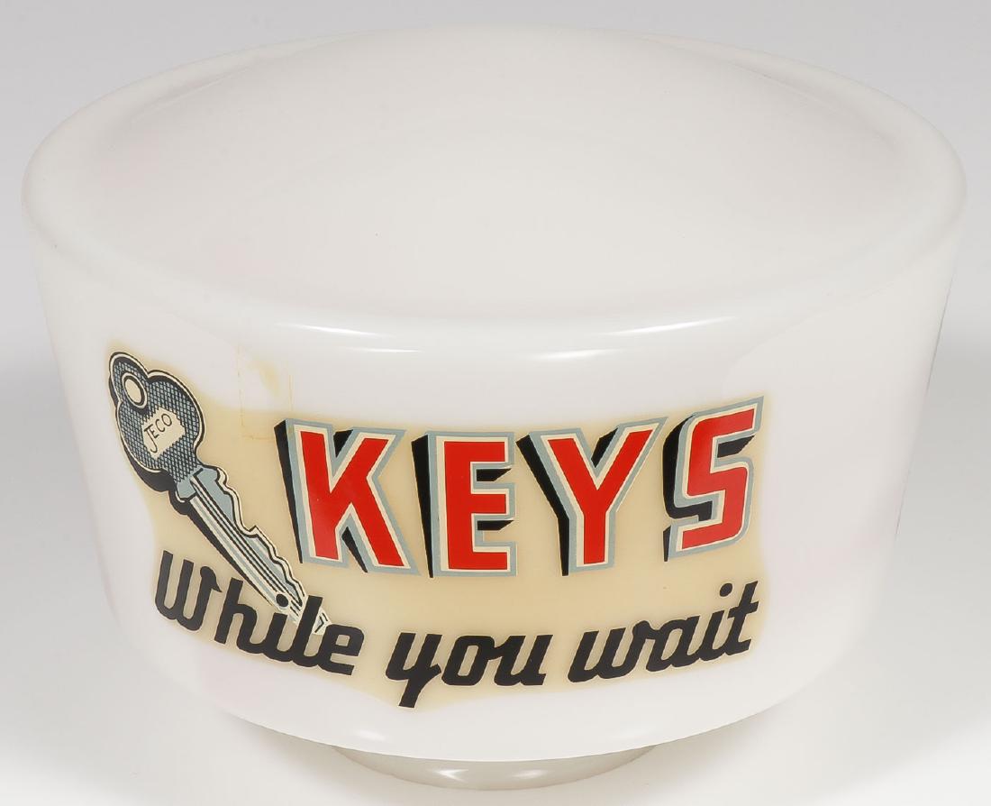 A HARDWARE STORE ADVERTISING LANTERN GLOBE: A HARDWARE STORE ADVERTISING LANTERN GLOBE. A white glass lantern globe with "Keys While You Wait" etched on sides usually found atop a key making machine. Height 7 inches (18 cm). Provenance: