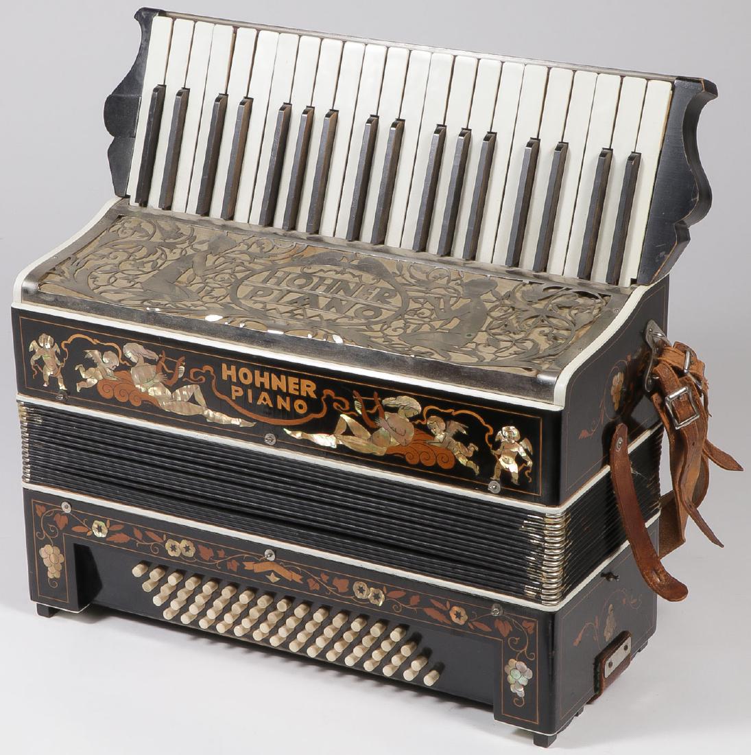 A GROUP OF 4 VINTAGE ACCORDIONS: A GROUP OF 4 VINTAGE ACCORDIONS. Comprising a large Hohner Piano accordion, a small Hohner accordion, an Eagle brand accordion, and a Magnus accordion. Together with a toy accordion. Greatest height 1