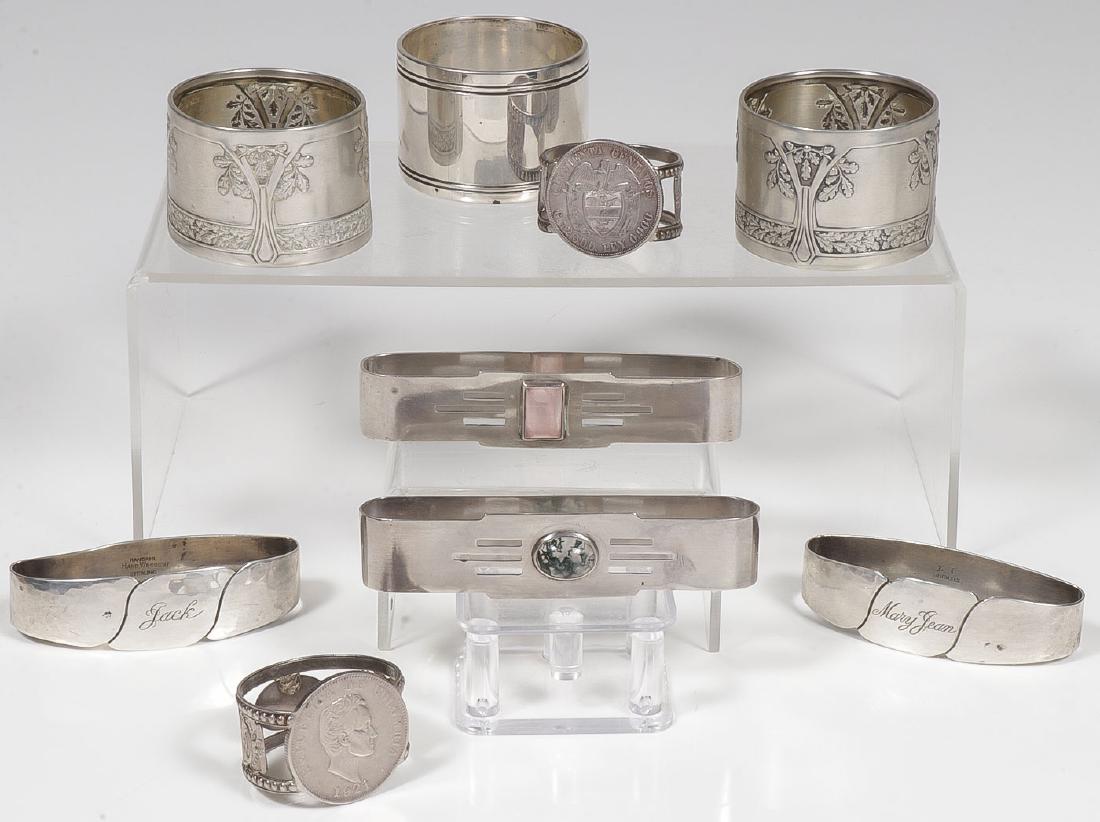 4 PAIRS OF STERLING MATCHING NAPKIN RINGS: 4 PAIRS OF STERLING MATCHING NAPKIN RINGS. Comprising a pair set with Columbian silver Centavos, a pair of gemstone Art Deco style examples, a pair of Randahl hand wrought sterling wedding napkin ring
