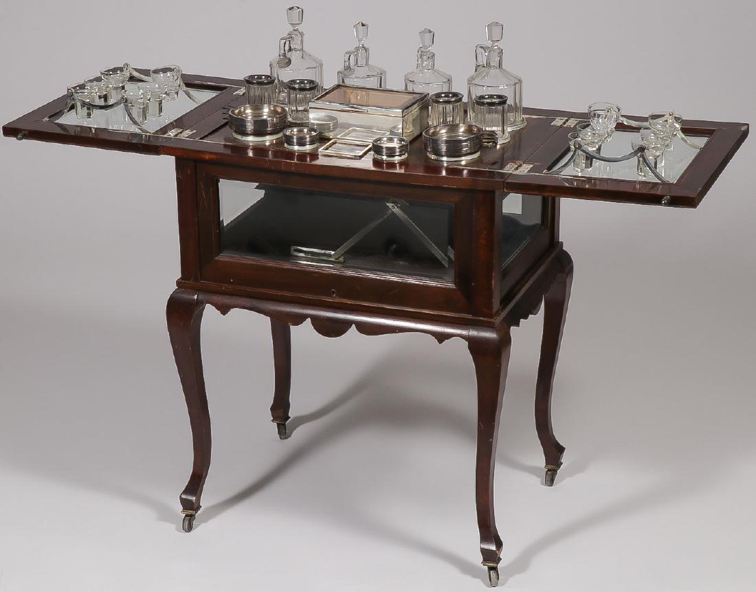 A VINTAGE WALNUT & GLASS POP UP BAR TROLLEY: A VINTAGE WALNUT & GLASS POP UP BAR TROLLEY. With beveled glass sides and top, fitted interior with cut glass decanters and glasses and coasters, cabriole legs, on wheels. Height 28.5 inches (72 cm).