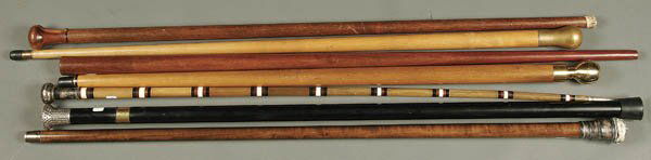 A COLLECTION OF 7 WALKING STICKS comprising one o: A COLLECTION OF 7 WALKING STICKS comprising one of bone & ivory with silvered head, circa 1920's. Together with 6 contemporary sticks, one with pool cue and one with glass flasks. Length 35 inches. Es