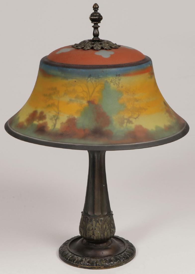 A PAIRPOINT REVERSE PAINTED SHADE: A PAIRPOINT REVERSE PAINTED SHADE & ASSOCIATED BASE, C. 1920. Comprising a reverse painted bell-shaped glass shade with slightly domed top and chipped ice finished surface painted with an autumn dusk 