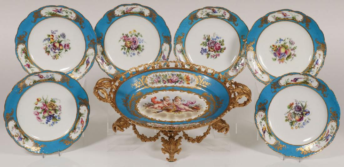 SEVRES HAND-PAINTED PORCELAIN, 19TH CENTURY: A HAND-PAINTED SEVRES ORMOLU MOUNTED BOWL & PLATES, 19TH CENTURY. Comprising a large and impressive oval bowl with turquoise ground, the interior with hand-painted scene of putti framed in gilt scroll