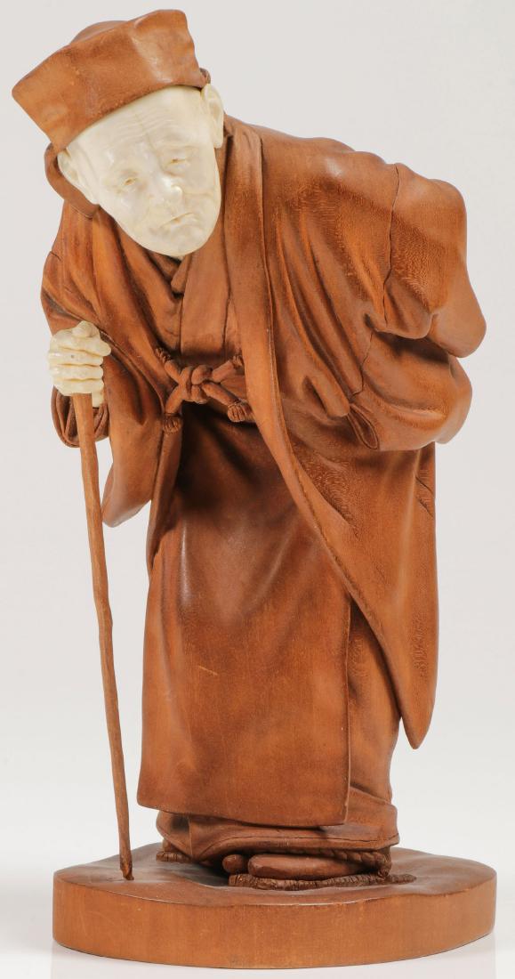 A JAPANESE CARVED FIGURE, MEIJI: A JAPANESE CARVED FIGURE, MEIJI PERIOD. Depicting a finely carved elderly man stooped over with walking cane in one hand and prayer beads in the other. Carved in full-round with good anatomy and propo
