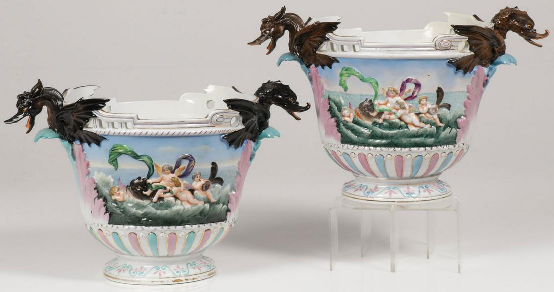 PAIR OF FRENCH PORCELAIN WINE COOLERS, 19TH C: PAIR OF SPECTACULAR FRENCH PORCELAIN WINE COOLERS, 19TH C. Comprising a pair of matching French porcelain wine coolers. Urn shaped resting on spread foot, the sides with relief decoration of putti ato
