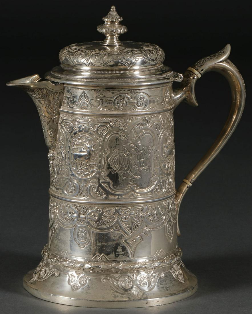 AN IMPRESSIVE SILVER FLAGON TANKARD, GLASGOW 1883: AN IMPRESSIVE SILVER FLAGON TANKARD, GLASGOW 1883. Of cylindrical form with wide spread foot banded in a laurel wreath, the body overall engraved with strapwork scrolling vines, flowers and four oval 