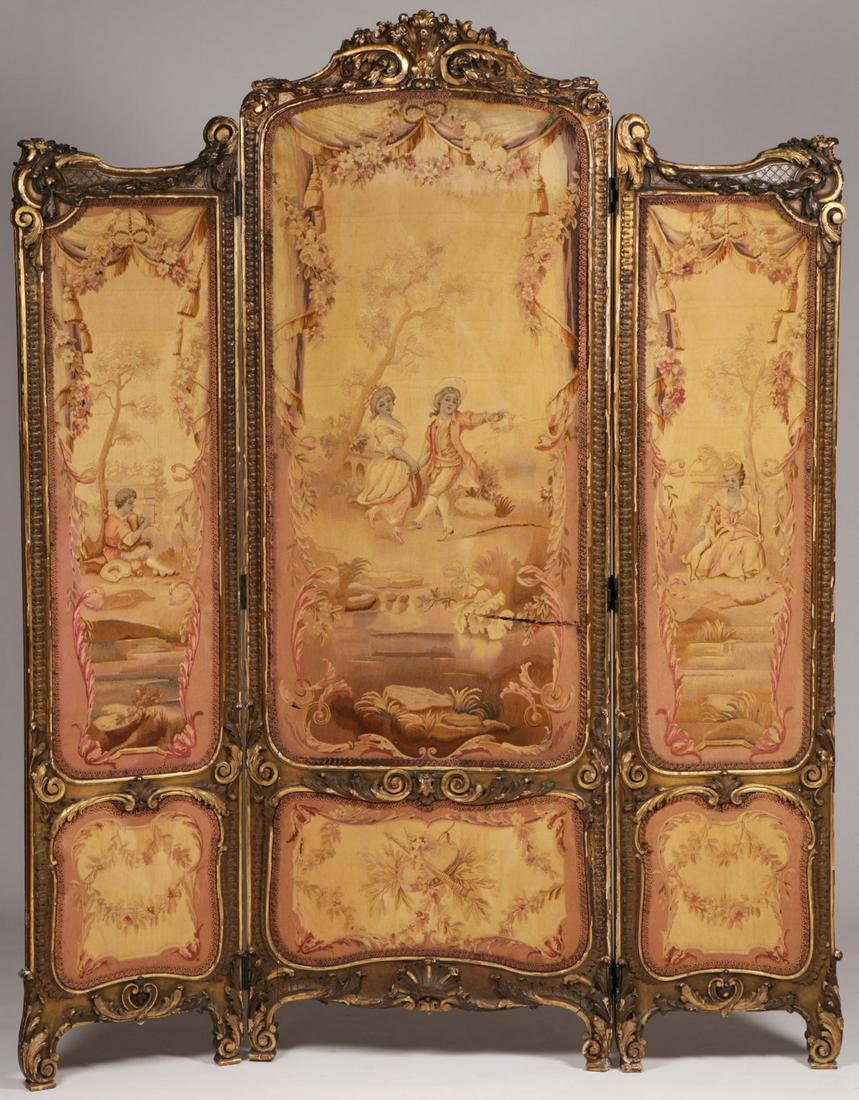 A LOUIS XV STYLE AUBUSSON AND CARVED SCREEN: A LOUIS XV STYLE AUBUSSON AND CARVED SCREEN. Comprising a three section screen with ornately carved gilt wood frame and Aubusson embroidered panels each depicting a scene of people at leisure. Some da