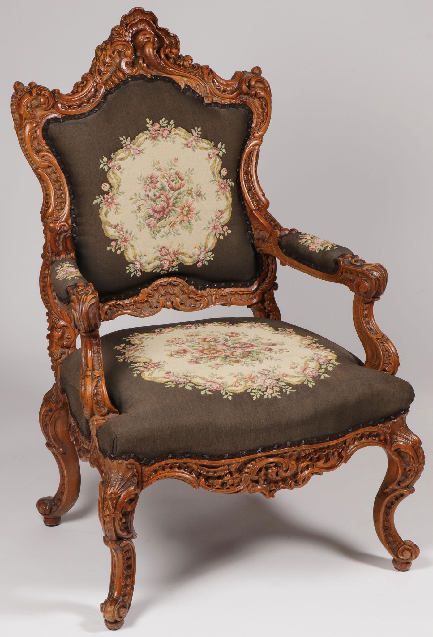 A FINELY CARVED ROCOCO REVIVAL ARMCHAIR: A FINELY CARVED ROCOCO REVIVAL ARMCHAIR. Comprising an ornately carved wood frame with scrolled arms and reverse scrolled feet. The seat back and armrest all upholstered with floral needlepoint fabric