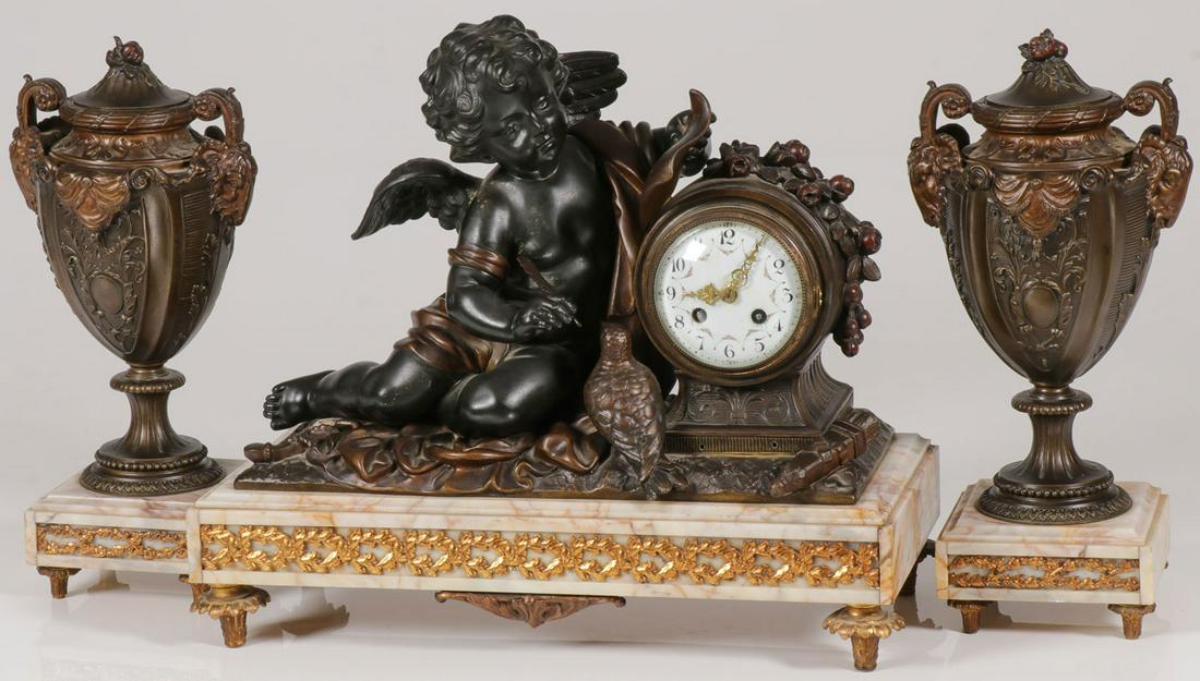 A FRENCH FIGURAL MANTLE CLOCK GARNITURE SET: A FRENCH FIGURAL MANTLE CLOCK GARNITURE SET. Comprising a patinated figural metal depiction of a putti writing with quill pen on scroll next to dial with Arabic numbers and floral decoration, all set