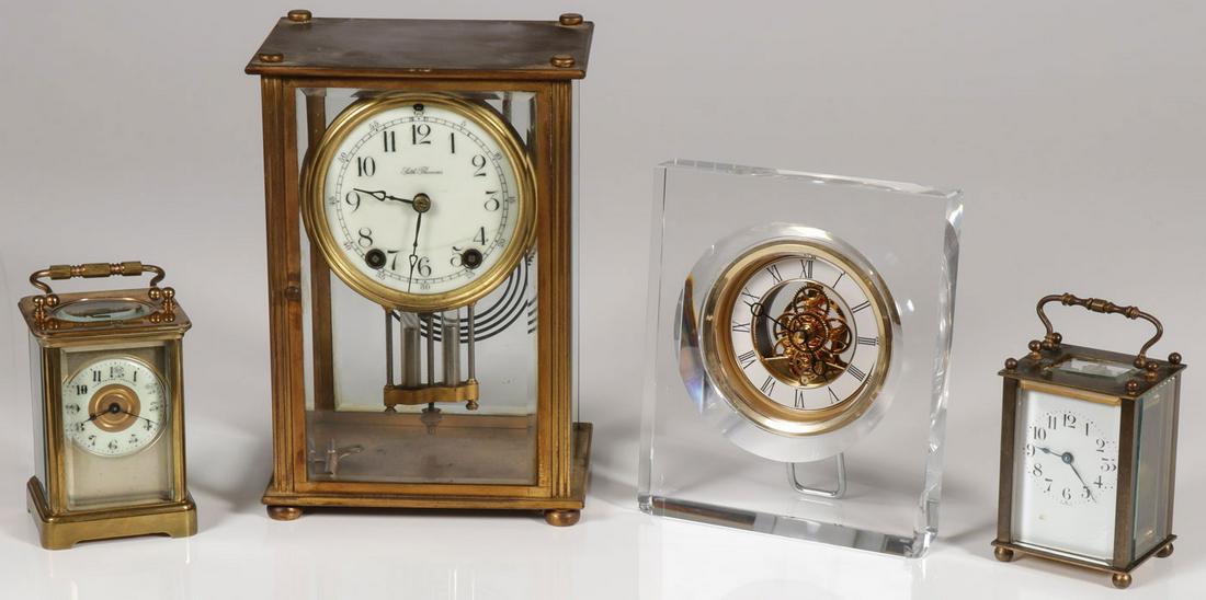 A GROUP OF FOUR CLOCKS: A GROUP OF FOUR CLOCKS. Comprising a Thomas Yates and Preston carriage clock, a French carriage clock, a Seth Thomas glass case clock, and a Hoya glass and brass desk clock. Greatest height 9.5 inche