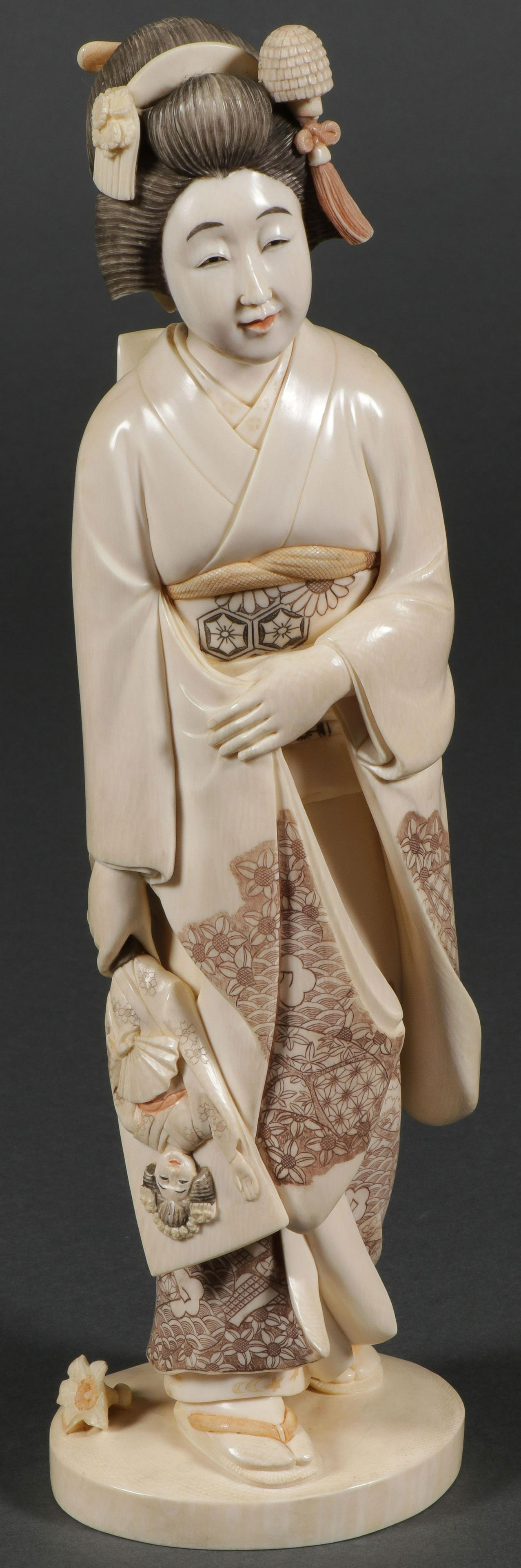 LARGE JAPANESE CARVED GEISHA, MEIJI PERIOD: LARGE JAPANESE CARVED GEISHA, MEIJI PERIOD. Comprising a large and finely carved figure of a Geisha, carved in full round, of good proportions and anatomy with flowing robes and hair, her kimono profu
