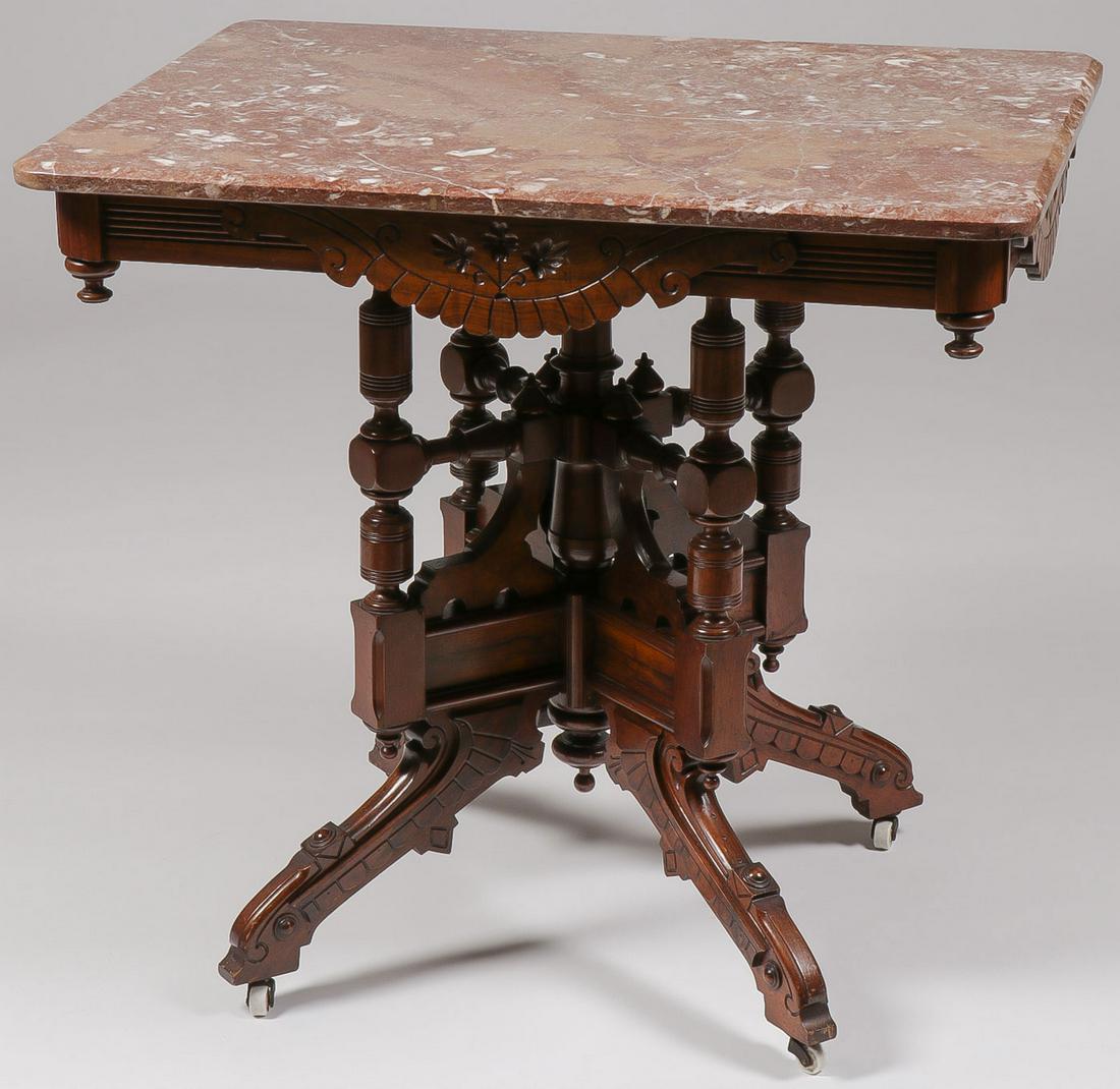 A VICTORIAN WALNUT PARLOR TABLE: A VICTORIAN WALNUT PARLOR TABLE. The variegated mulberry marble top over a reeded-carved frieze with applied chip-carved scalloped panels and pendent-drop corners, rising on carved and rondel-appointe