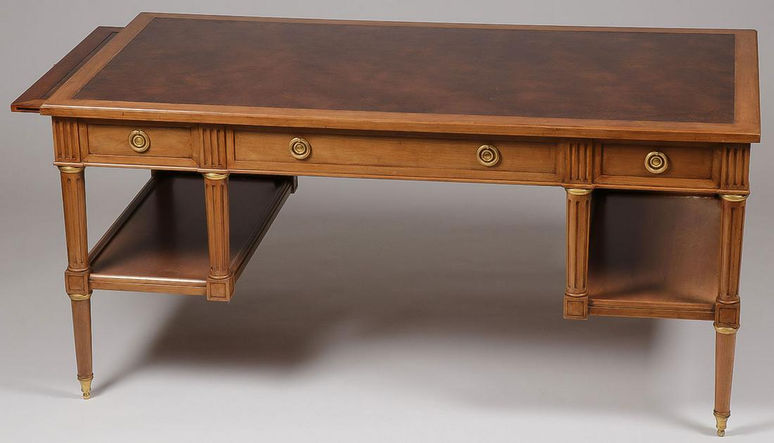 A CONTEMPORARY PARTNER STYLE DESK: A CONTEMPORARY PARTNER STYLE DESK. The rectangular top inset with tooled leather, the frieze fitted with central long drawer flanked by two shorter drawers, the verso with faux drawers, raised on four
