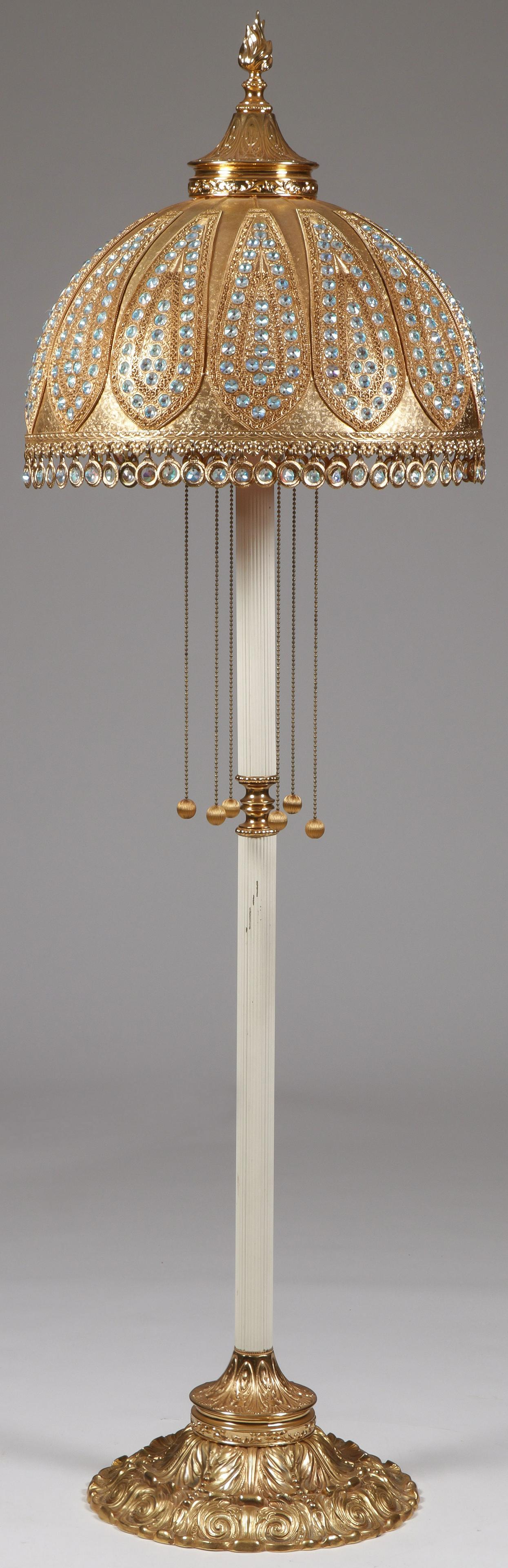 AN IMPRESSIVE ORIENTAL FLOOR LAMP: AN IMPRESSIVE ORIENTAL FLOOR LAMP. Comprising a large and impressive floor lamp in the oriental taste with elaborate gilt metal pierced shade set with paste stones atop a fluted central column and hea