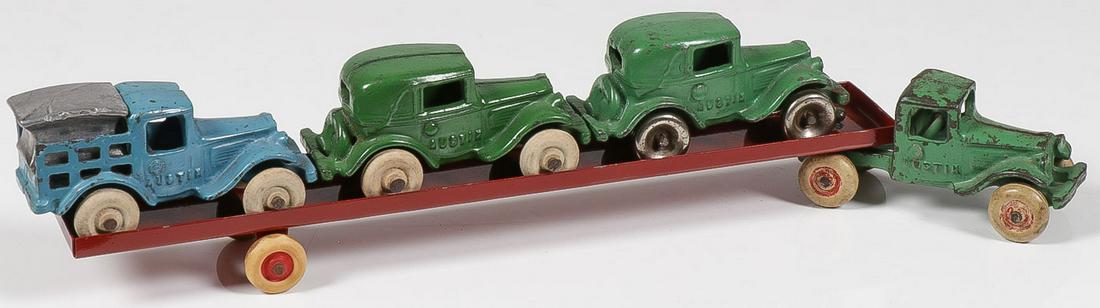 AN ARCADE CAST IRON CAR CARRIER C. 1930s: AN ARCADE CAST IRON CAR CARRIER C. 1930s. Comprising a green cab embossed on either side, Austin,, pulling a red pressed steel flatbed trailer containing 2 coupes, one with metal wheels, and a stake