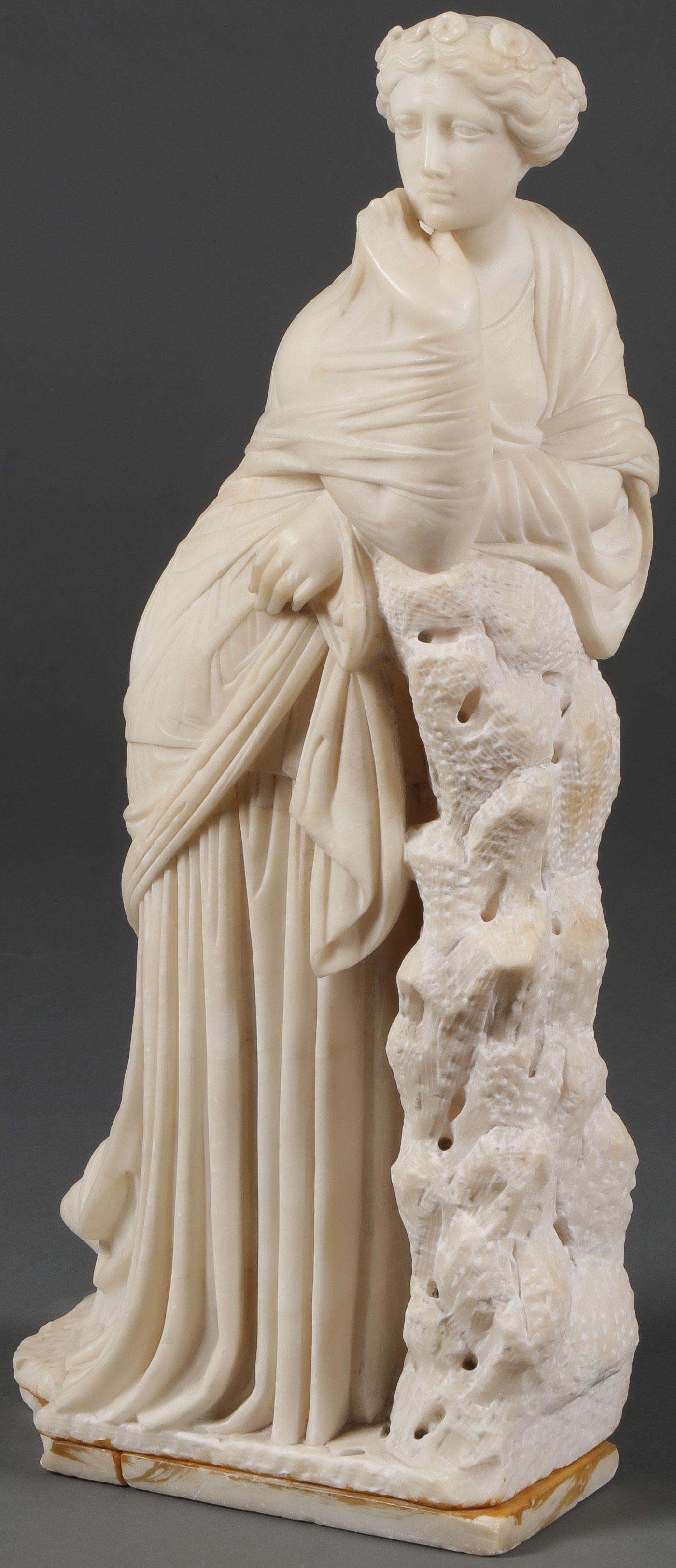 A CARVED MARBLE STATUE: A CARVED MARBLE STATUE, 19TH C. Comprising a carved marble statue of a classically adorned woman with floral hair wreath resting on a stump. Carved in full round of good proportions and anatomy with