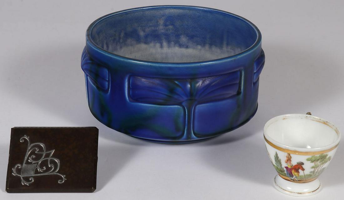 A DECORATIVE ARTS GROUP: A DECORATIVE ARTS GROUP. Comprising a Heintz sterling and bronze cigarette case, a Bretby English molded Art Nouveau art pottery vase, and a Meissen porcelain cup with hand-painted scene, damaged and 