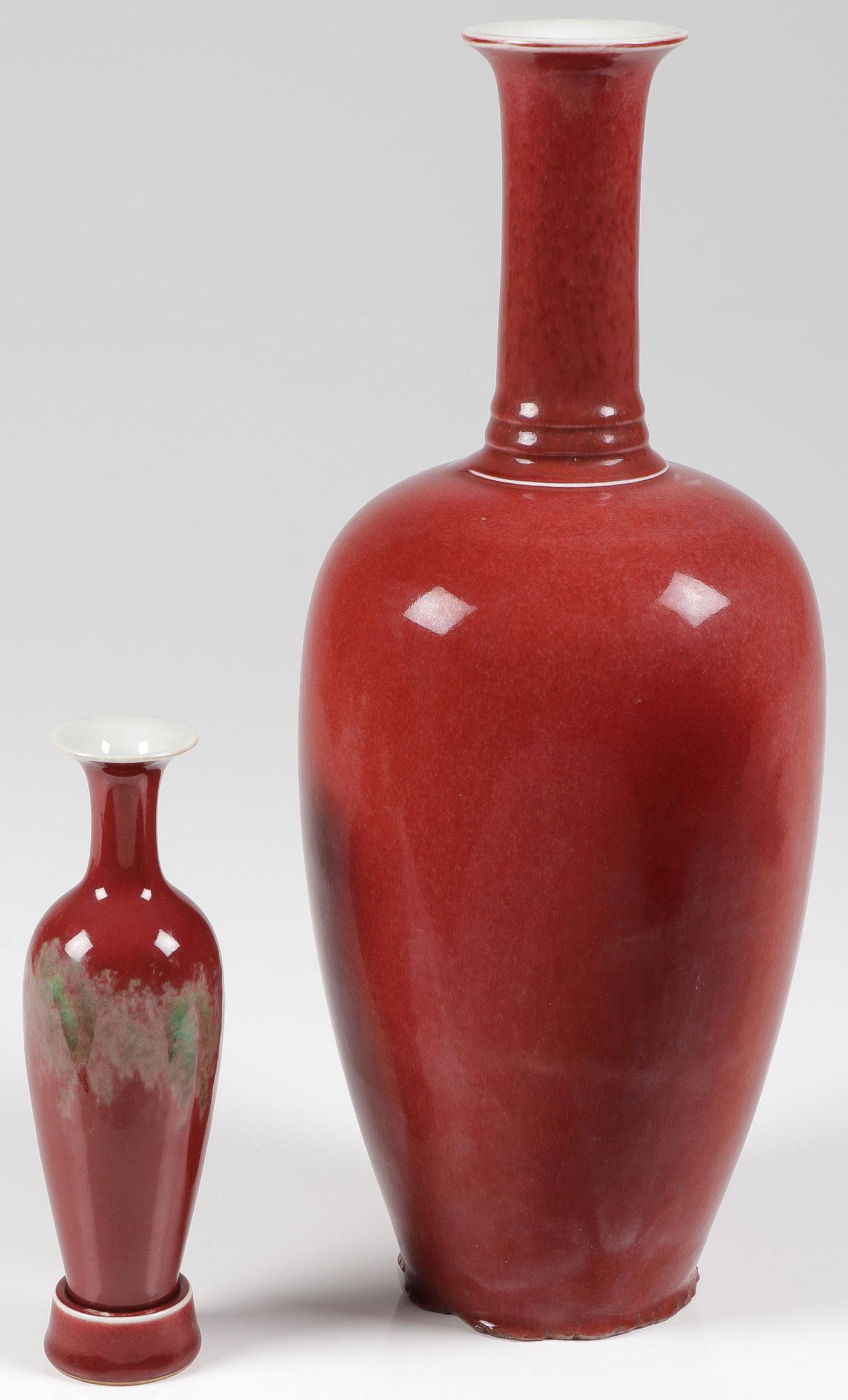 A PAIR OF CHINESE BLOOD RED VASES: A PAIR OF CHINESE BLOOD RED VASES. Comprising a small vase with ring holder, the underside with blue underglaze reign mark, height 8 inches. Together with a similar form vase with long neck and flared
