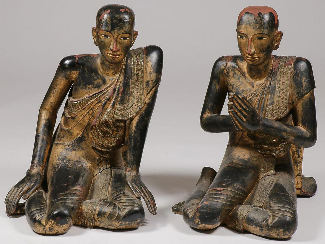A PAIR OF BURMESE BUDDHA DISCIPLES: A PAIR OF BURMESE BUDDHA DISCIPLES. Comprising two free standing gilt wood and black lacquer sculptures depicting the two Buddhist disciples Shariputra, depicted leaning forward, and Maudgalyayana, de