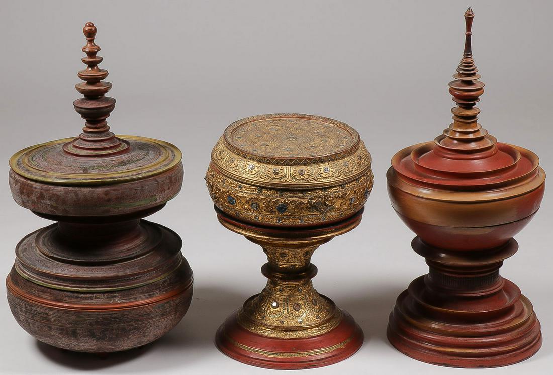 THREE BURMESE OFFERING VESSELS: THREE BURMESE OFFERING VESSELS. Comprising a gilt and lacquer vessel with inlaid colored glass on pedestal base, a red lacquer vessel with pedestal base and spire finial, and a red lacquer vessel with