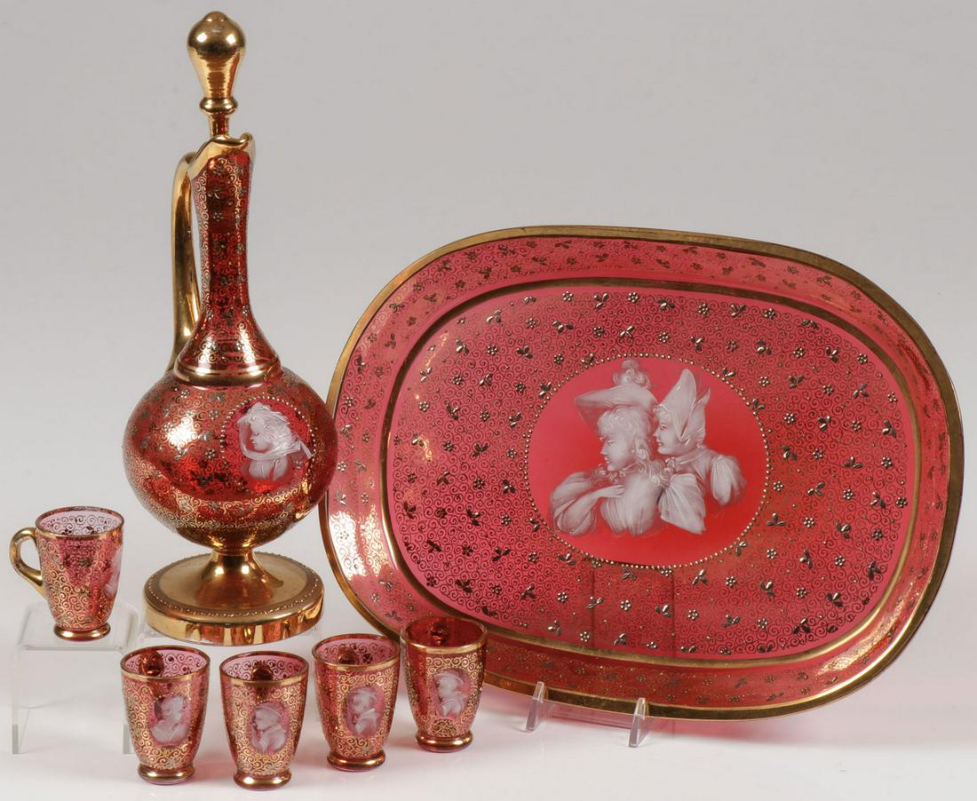 EXCEPTIONAL MARY GREGORY CRANBERRY LIQUEUR & TRAY: EXCEPTIONAL MARY GREGORY CRANBERRY LIQUEUR & TRAY. Comprising an exceptionally decorated cranberry Bohemian (AKA Mary Gregory) enamel and gilt decorated oval tray. Together with a six-piece liqueur se