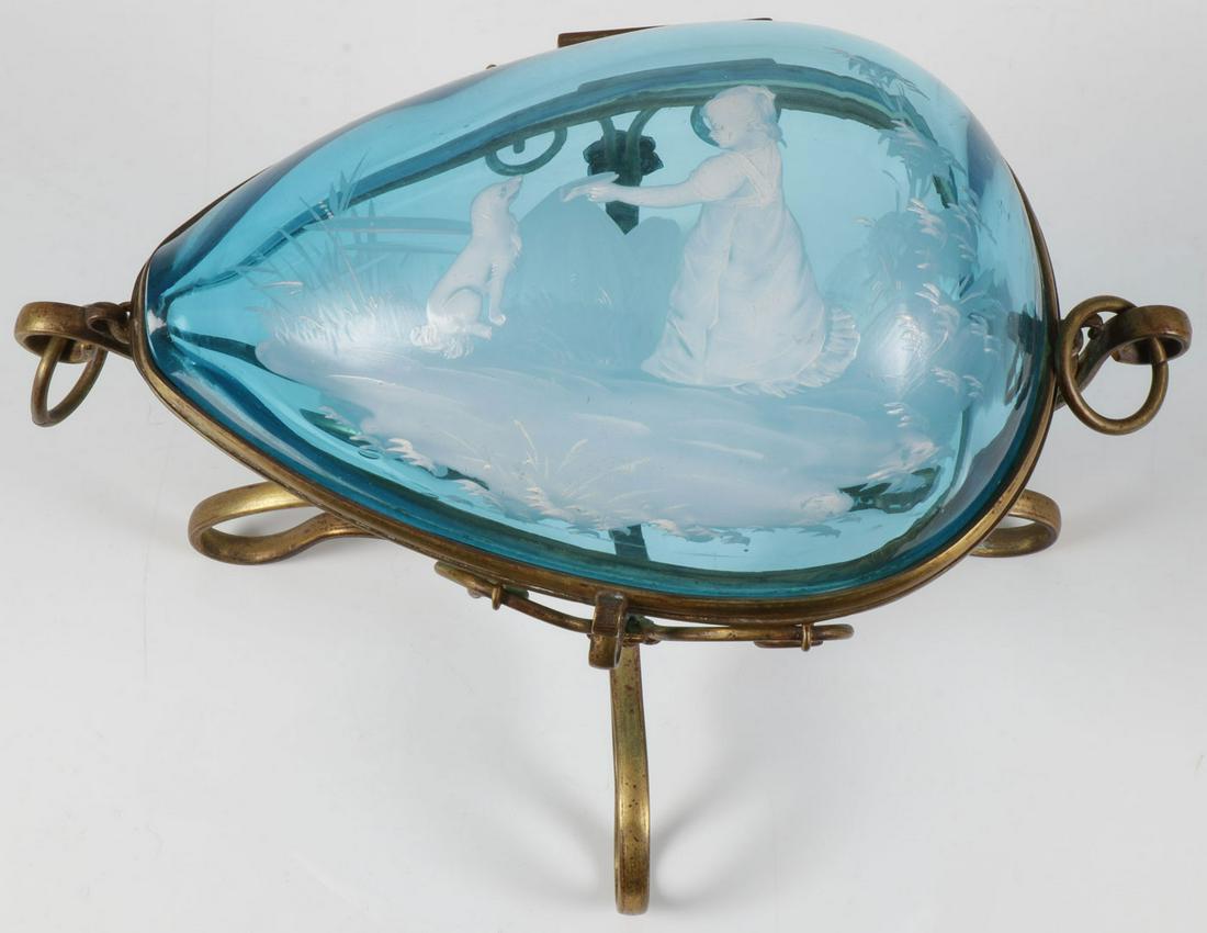 RARE MARY GREGORY EGG SHAPED BOX, C. 1890: RARE MARY GREGORY EGG SHAPED BOX, C. 1890. Comprising a scarce Bohemian (AKA Mary Gregory) enamel decorated sapphire blue egg form glass box. The two equal halves hinged and set in a gilt wire frame,