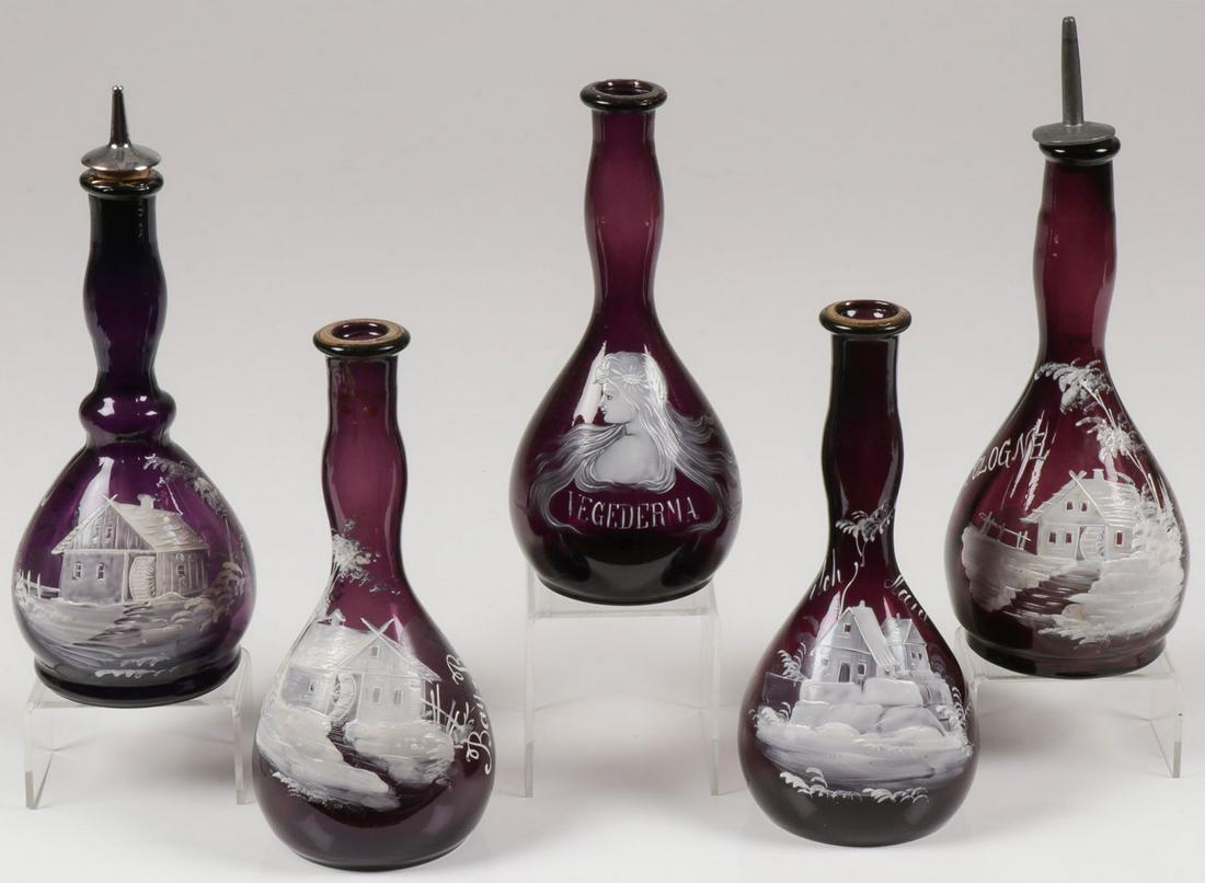 FIVE MARY GREGORY BARBER BOTTLES, C. 1890: FIVE MARY GREGORY BARBER BOTTLES, C. 1890. Comprising five individual Bohemian (AKA Mary Gregory) enamel decorated amethyst glass barber bottles. Four depicting a mill in a wooded landscape and inscri
