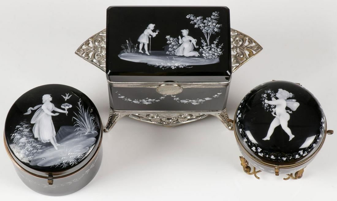 THREE MARY GREGORY BOXES, C. 1890: THREE MARY GREGORY BOXES, C. 1890. Comprising three exceptional Bohemian (AKA Mary Gregory) enamel decorated black glass boxes. One of casket form in silver-plated footed frame with medallion engraved