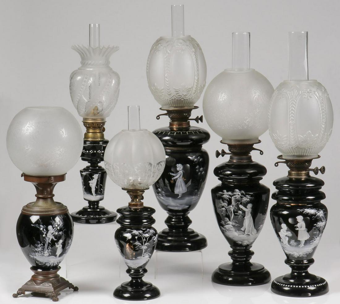 SIX MARY GREGORY OIL LAMPS: SIX MARY GREGORY OIL LAMPS. Comprising six Bohemian (AKA Mary Gregory) enamel decorated black glass lamps of various shapes and sizes, one electrified, four with removeable oil font, and each finely e