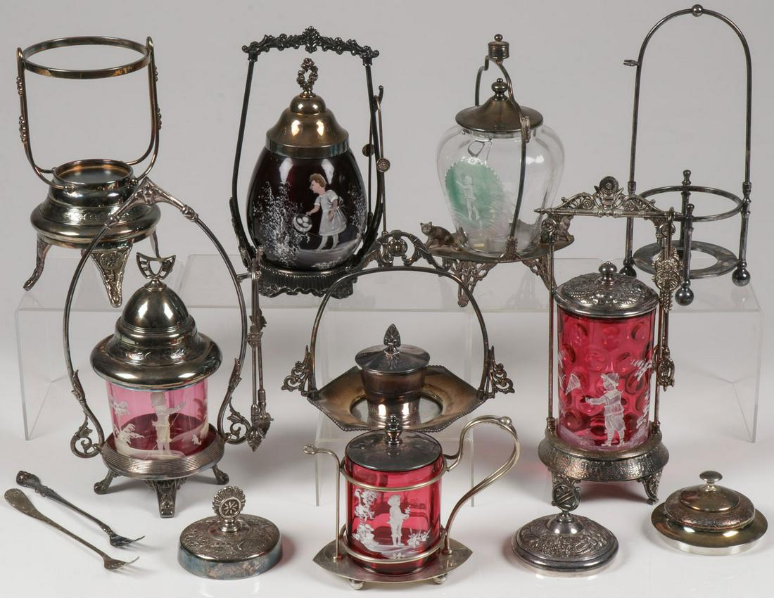 MARY GREGORY PICKLE CASTERS & FRAMES: MARY GREGORY CASTERS. Comprising five Bohemian (AKA Mary Gregory) enamel decorated pickle casters of various shapes, sizes, and colors including three in cranberry, one in ruby, and one clear. Each wi