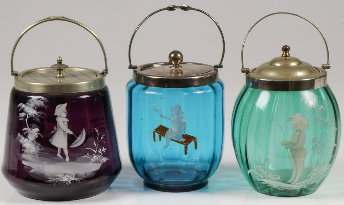 THREE MARY GREGORY CRACKER JARS, C. 1900: THREE MARY GREGORY CRACKER JARS, C. 1900. Comprising three Bohemian (AKA Mary Gregory) enamel decorated glass cracker jars in various shades including amethyst, sapphire, and emerald. The amethyst ex