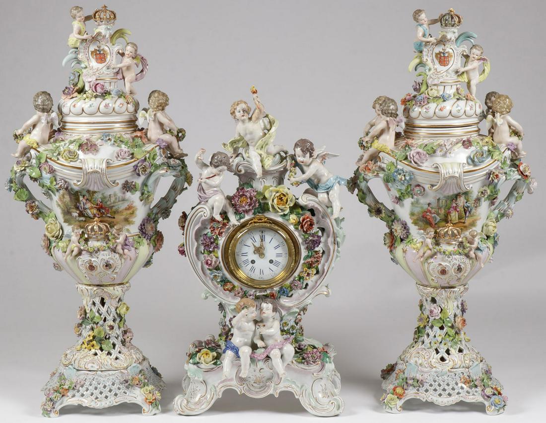 A MONUMENTAL CARL THIEME DRESDEN GARNITURE C 1900: A MONUMENTAL CARL THIEME DRESDEN GARNITURE C. 1900. Of Rococo revival taste each elaborately garnished with applied florals and full figured putti. The lidded and bolted urns further decorated with ha
