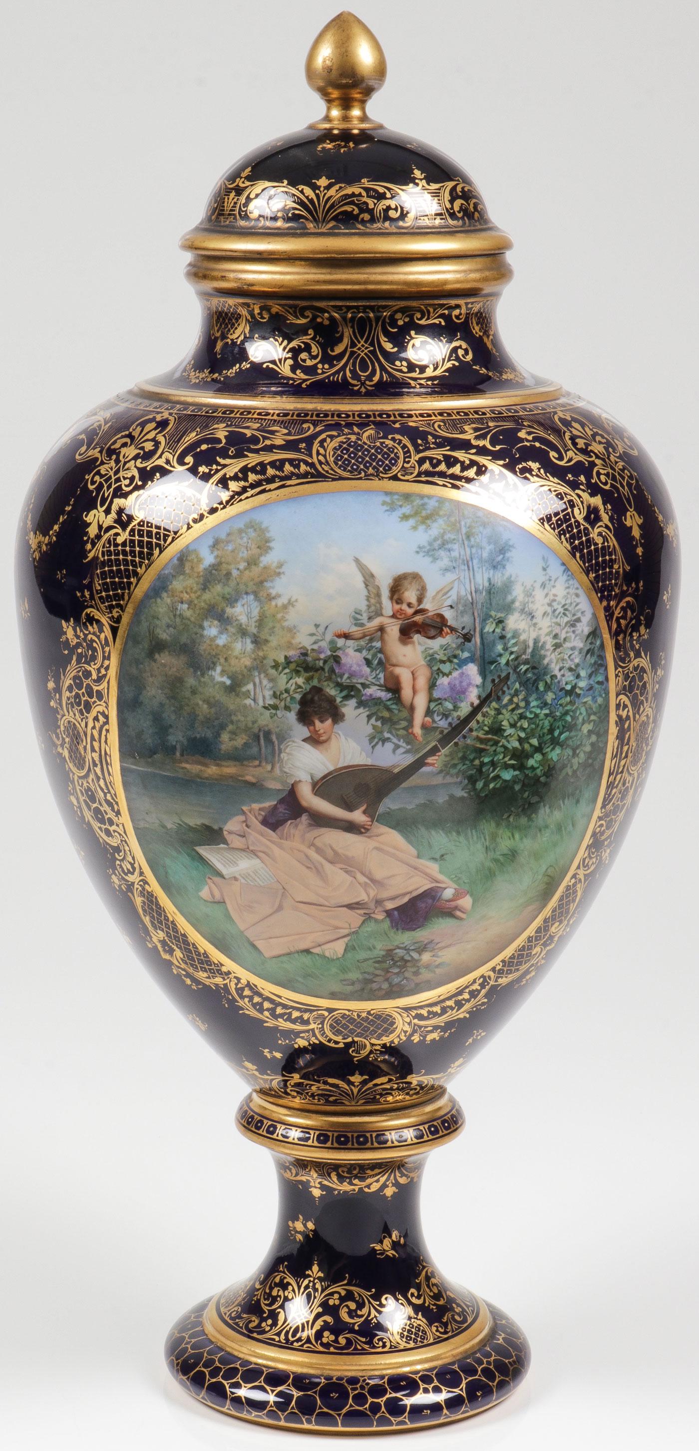 SPECTACULAR HAND-PAINTED DRESDEN URN: SPECTACULAR HAND-PAINTED DRESDEN URN. With heavy gilt decoration on cobalt ground, the obverse decorated with an exceptionally well painted beautiful maiden and a putto playing stringed instruments in
